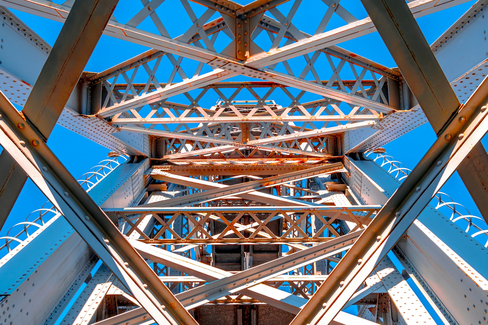 Abstract view of a steel bridge structure against blue sky
