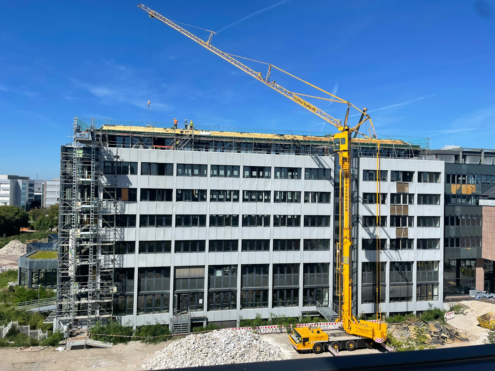 a crane is standing in front of a building under construction